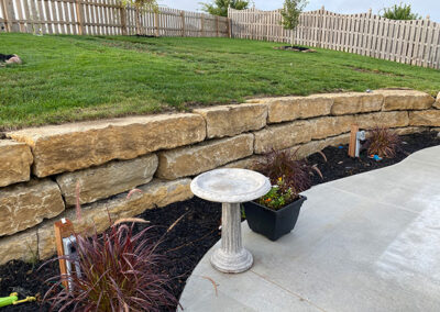 large stone retaining wall with landscaping